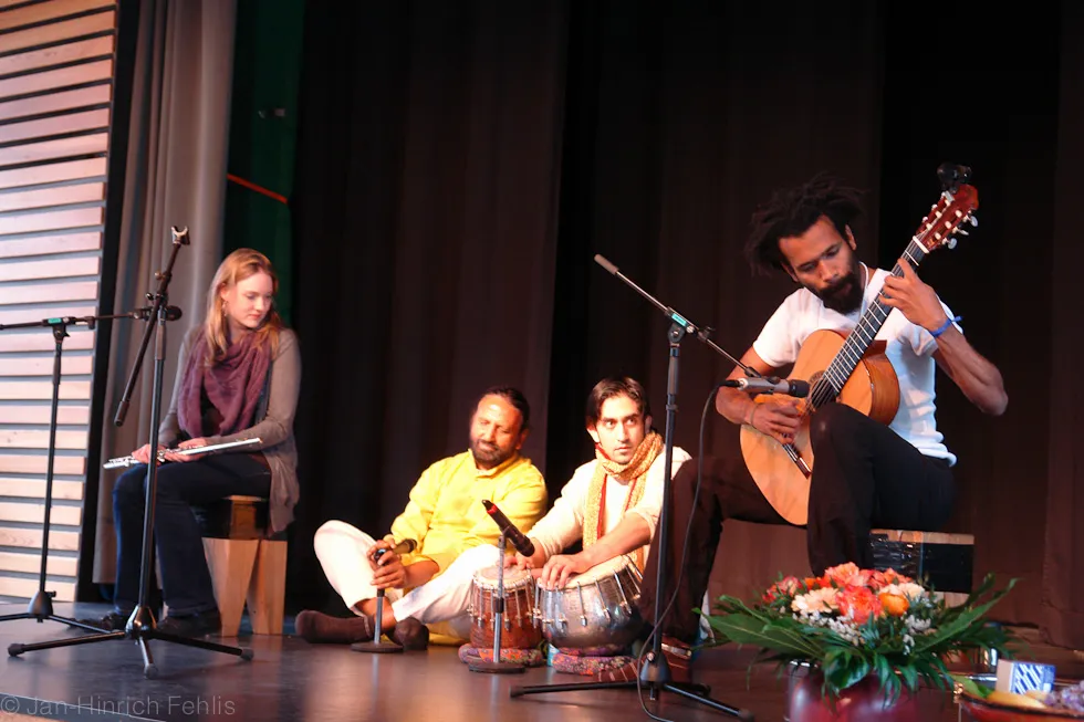 Satish Kumar Joshi mit Musikern an Gitarre und Tabla auf der Bühne